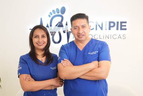 Equipo de Tecnipie Podoclínicas con uniforme azul frente al logo de la clínica